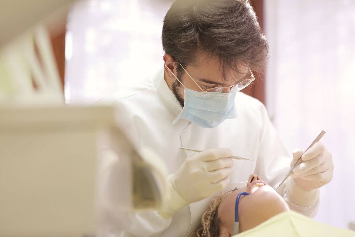Dentist showing a patient dental implant and bridge tooth replacement options in Aurora